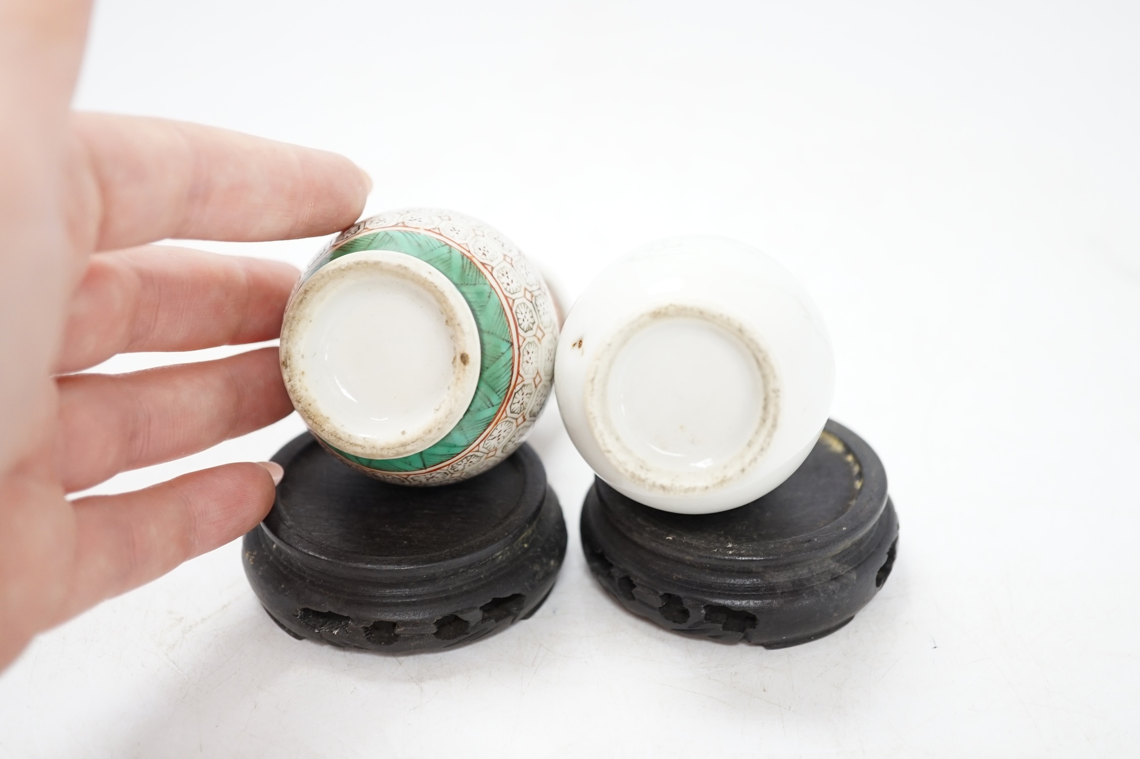 Two miniature Chinese porcelain vases, on hardwood stands, largest 9cm high. Condition - fair